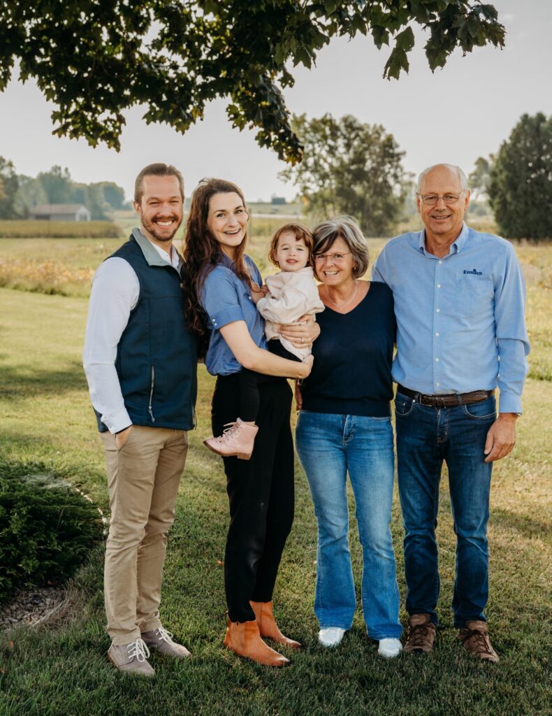 Esmilco founders and family members smiling together on the farm, representing the people behind the brand